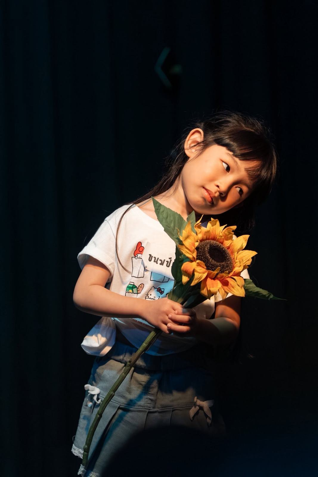 นักเรียนถือดอกทานตะวันบนเวที